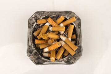 Ashtray butts cigarette on white