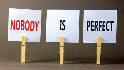 Nobody is perfect symbol. Concept words Nobody is perfect on beautiful white paper on clothespin. Beautiful grey background. Business motivational lifestyle and nobody is perfect concept. Copy space.