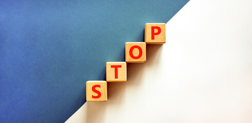 Stop symbol. Concept word Stop on beautiful wooden blocks. Beautiful white and blue background....