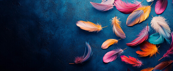 Colorful feathers scattered on dark blue background, creating a vibrant and airy composition, showcasing texture and color, ideal for design projects