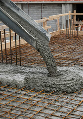 Heavy-duty concrete pouring over ferralla framework at a new building site.