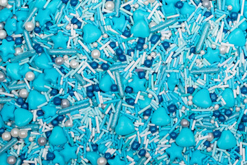 Close-up of blue heart-shaped candy with a glossy surface, forming a seamless background. Sweet confectionery texture perfect for Valentine's Day, love, and romance themes.