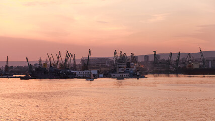 Fototapeta premium Varna harbor scene during sunrise with industrial cranes