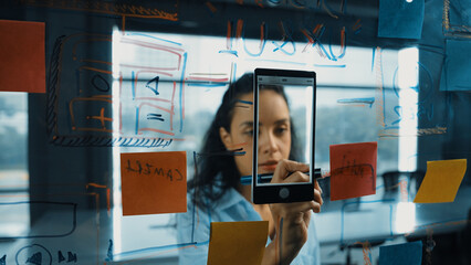Young hispanic employee writing on colorful sticky notes. Smart businesswoman sharing marketing...