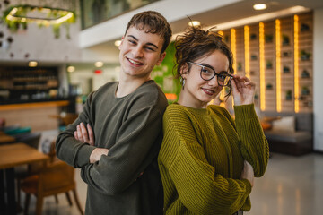portrait of couple boyfriend and girlfriend stand arm crossed at cafe
