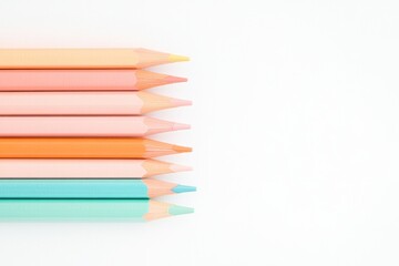 Obraz premium row of diverse colored pencils arranged on white background with plenty of copy space