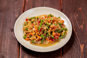 Couscous with vegetables in sauce on a plate on the table