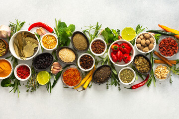 A collection of various spices and herbs on a gray background, perfect for enhancing dishes with...