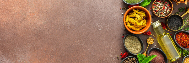 A visually striking arrangement of fresh spices and herbs on a brown surface, highlighting their...