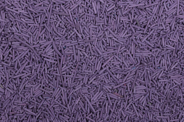 A high-resolution close-up of uncooked purple vermicelli pasta, showing tiny cylindrical noodles spread across the frame. Perfect for food backgrounds, ingredient concepts, and packaging designs.
