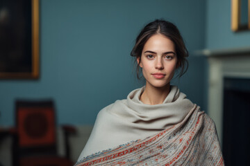 Portrait of a young woman wrapped in a scarf in a historic indoor setting