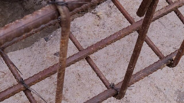 Construction workers using reinforced tmt steel bar with ease at the construction site, Reinforced bar (rebar). TMT steel rods tied together forming the core of concrete