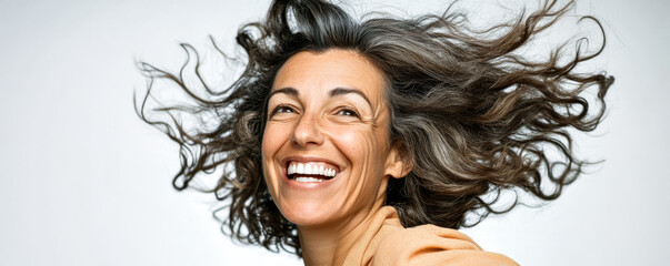 Fototapeta premium Woman with flowing hair enjoys joyful moment and smiles brightly in studio setting