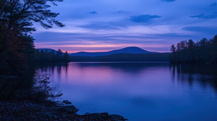 Calm evening reflection at the lake with colorful sky above mountains