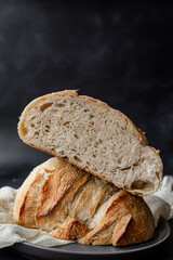 Artisan Sourdough Bread with Open Crumb – Crusty Homemade Loaf on Dark Background for Bakeries, Food Bloggers, and Culinary Photography– Sliced in Half