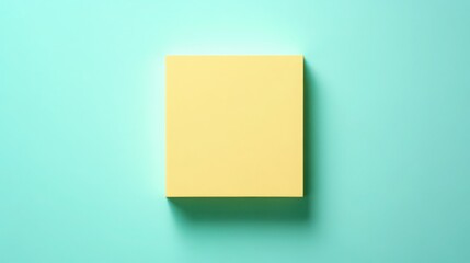 Fototapeta premium Stylish yellow paper block on light turquoise background, ideal for notes
