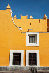 Facade of a yellow house with a lot o windows.