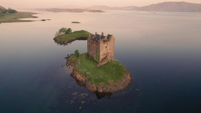 Castle Stalker Island in Scotland at Sunrise. Drone Backwards from Close to Far.