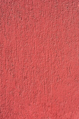 A close-up shot of a textured red wall, showcasing its rough surface and vibrant color under natural light