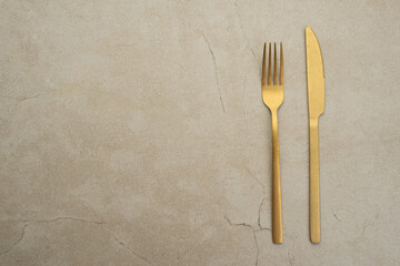 Set of golden metal cutlery on stone table