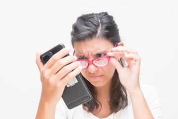 woman with glasses reading with difficulty the cell phone, myopia, eye health