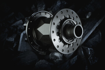 Black bicycle hub placed on dark coal background. Professional bike bearings.