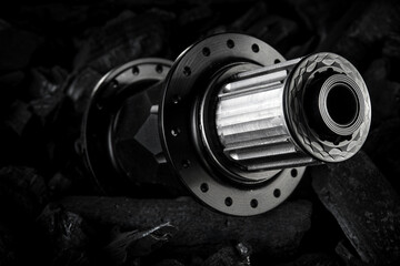 Black bicycle hub placed on dark coal background. Professional bike bearings.