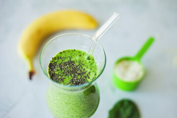 Healthy green protein smoothie, packed with spinach, banana and vanilla protein powder, topped with chia seeds, great for weight loss, detox and a rich source of vitamins, minerals, and antioxidants