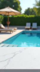 Fototapeta premium white marble tabletop features blurry outdoor pool scene loungers