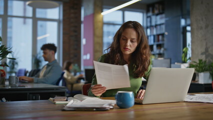 Lady manager examining documents in office closeup. Smiling successful woman