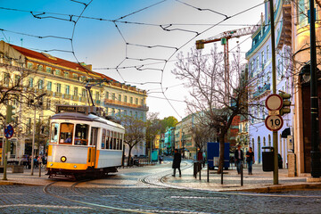 Tranvía tipico avanzando por calle empedrada de Lisboa, con edificios coloridos.
Nostalgia y...
