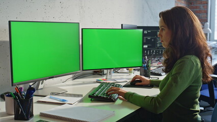 Retoucher working greenscreen monitors typing computer keyboard office closeup