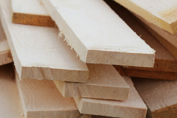 Stacks of pine wood planks. Natural rough wooden boards boards, lumber, industrial wood, timber.