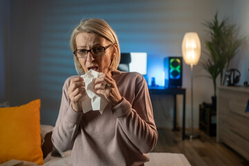 Sick Woman. Flu. Woman Caught Cold. Sneezing into Tissue. Mature woman suffering from cold. Sick...