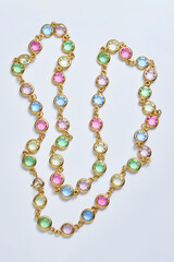 Elegant Gold Necklace With Colorful Gemstones on a White Background..
