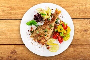 Fried tasty fish steak with cooked vegetables