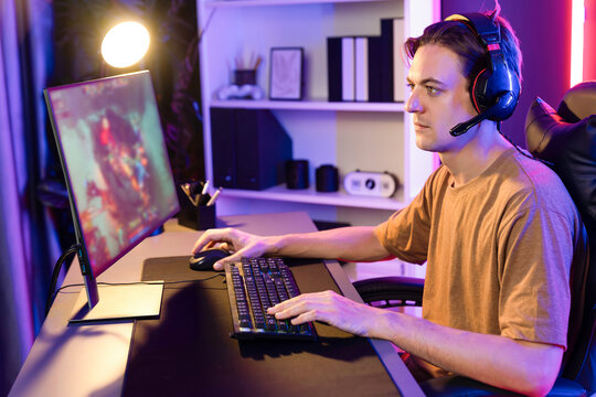 Host channel concentrated smart gaming streamer playing the fighting Moba on computer screen with muptiplayers or single at battle arena . Esport live streaming at neon digital light room. Pecuniary.