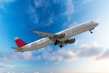 Airplane flying in blue sky with clouds, travel background