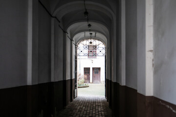 Fototapeta premium Archway Leading to Courtyard with Wooden Doors and Iron Gate