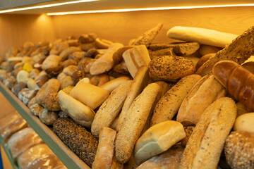 Large pile of fresh bread displayed on the counter. Dairy products concept.