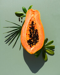 Papaya fruit over green background, half of fresh exotic fruits with seeds. Halved fresh organic...