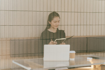 Focused Productivity: A woman deeply engrossed in her work, sitting at a desk with a laptop and a...