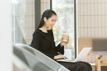 Coffee Break Productivity: A young woman enjoys a moment of calm during her workday, sipping coffee...