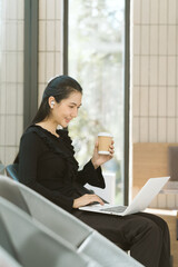 Modern Businesswoman on the Go: A stylish young businesswoman, effortlessly chic in her all-black...