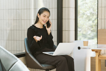 Businesswoman on a Call: A sophisticated businesswoman is immersed in a phone conversation while...