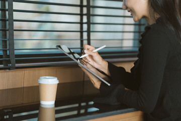 Digital Workspace: A modern professional engrossed in her work on a tablet, using a stylus pen,...