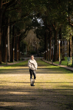 Female tourist walking through sunny alameda calvario park, capturing scenic views of combarro's traditional architecture and historic horreos in pontevedra, spain