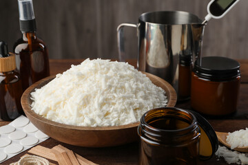 Soy wax and other supplies for making candles on wooden table, closeup