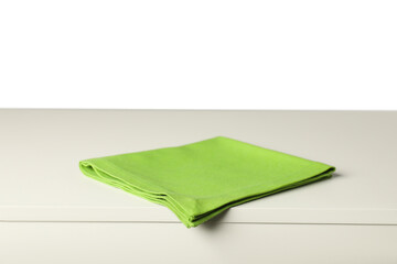 Green napkin on light table against white background