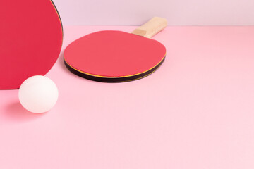 Two tennis rackets and white ball on a pink background. Creative ping pong composition with place for text.